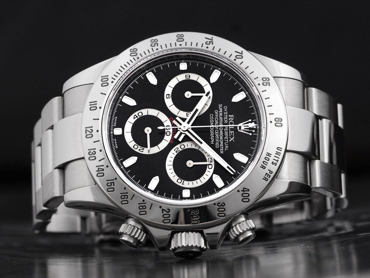 Stainless steel Rolex Daytona with black dial on a dark reflective surface